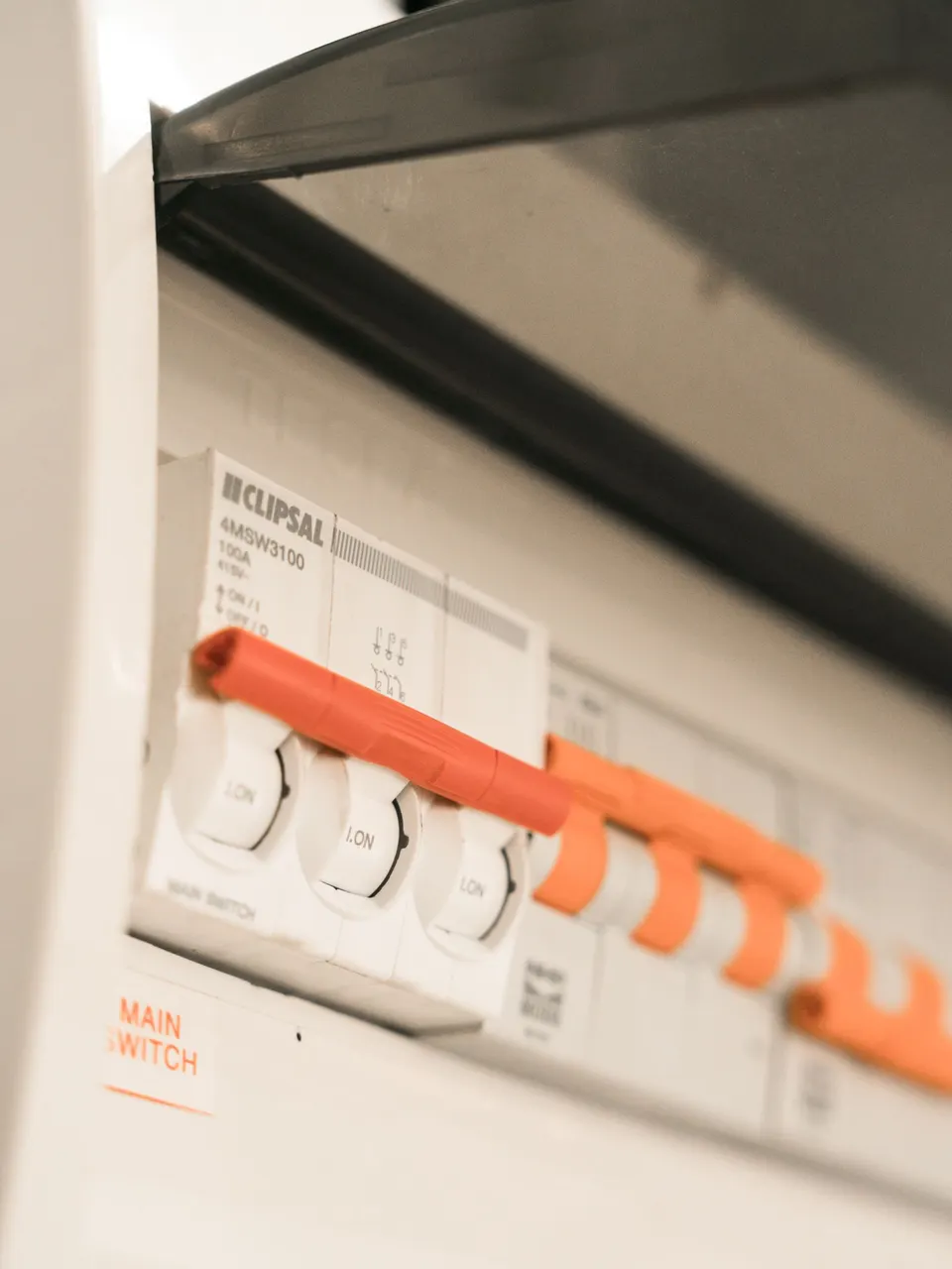Close-up of an Australian Clipsal main switch and safety switches inside a residential switchboard